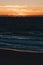 Sunset over the Indian Ocean in City Beach in Perth with silhouettes of swimmers and surfers in the ocean water