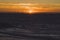 Sunset over the Indian Ocean in City Beach in Perth with silhouettes of swimmers and surfers in the ocean water