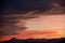 Sunset over jagged mountains with dramatic cumulus - silhouette image