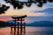 Sunset over the Japanese traditional red Torii gate shrine standing in the river of Itsukushima
