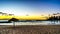 Sunset over the lagoon and beach with thatched umbrellas under blue sky on the West Coast of Oahu