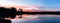 Sunset over the lake, the red sunlight, panorama, romantic in na