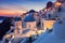 Sunset over local church with blue cupola in Oia village, Santorini i