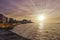 Sunset over Malecon and Atlantic Ocean with residential building and visible sun rays