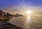 Sunset over Malecon and Atlantic Ocean with residential building and visible sun rays