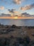 Sunset over the mediterranean sea with bushy landscape on the foreground