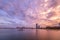 Sunset over moored sailboats and high-rise buildings.