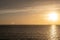 Sunset over Mykonos island, Cyclades, Greece. Lighthouse, orange yellow sky sparkle sea. Vertical