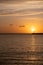 Sunset over Mykonos island, Cyclades, Greece. Lighthouse, orange yellow sky sparkle sea. Vertical