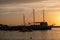 Sunset over Mykonos island, Cyclades, Greece. Moored ship at port, beacon orange sky sparkle sea