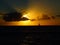 Sunset over the Ocean with Beams of Light and Silhouette of Sail