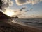 Sunset over the ocean with waves moving to shore