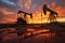 Sunset over an oil field with rusted derricks reflected in water