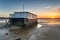 Sunset over an old wooden houseboat on the shore of Bramble Bush Bay