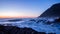 Sunset over the Pacific ocean. Long exposure photo of waves crashing onto basalt rocks.