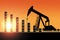 Sunset Over Pumpjack Silhouette and Oil Barrel Chart