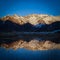 Sunset over the Pyrenees mountains with the reflection of the peaks in the water of the lake