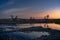 Sunset over a river with a pebbly shore.