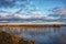 Sunset over the river. Pile moorings are visible from the water. Europe.