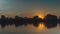Sunset over the river. Trees and clouds are reflected in the water. Smoothly zooming in and out of the camera. A timelapse of natu