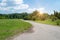 Sunset over the road. Sunrise  in summer beautiful park. Bright sunny day in park. The sun rays illuminate green grass and trees.