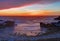 Sunset over rocks and sand at Asilomar State Beach in California