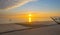 Sunset over sea along a beach below a blue cloudy sky at fall