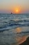 Sunset over the sea. Beautiful sky and sea waves in the rays of the setting sun. in the background a ship.