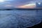 Sunset over the sea. Colorful blue skyline with clouds with smooth wave water flow on the beach. Beautiful sunset sky background.