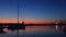 Sunset over the sea port. Yacht, lighthouse and view toward city lights