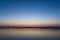 Sunset over the sea reflected in the wet sand of a beach