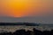 Sunset over the sea with silhouette of a Dhow boat