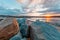 Sunset over shallow waters with huge boulders.