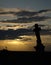 Sunset over the silhouette of a damaged crucifix