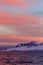 Sunset over snow and sharp mountain peaks in Weddel Sea near Antarctica Peninsula