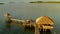 Sunset over wooden beach bar in sea and hut on pier in koh Mak island, Trat, Thailand