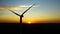 Sunset panorama by a large wind turbine in the middle of a large field