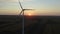 Sunset panorama near a large wind turbine on a huge field