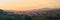 Sunset panorama of Transylvanian village surrounded by hills, at Petrestii de Jos, Romania - view from Turda gorge
