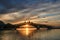 Sunset and People on a wooden footbridge in the harbor