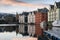 A sunset photograph of beautiful buildings reflecting off the water, with a blue sky with clouds in the background