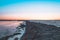 Sunset on the pier by the frozen Baltic sea