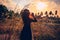 Sunset portrait of beautiful young woman on a field