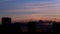 Sunset in progress over dark city silhouette - Time Lapse 4K VIDEO