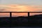 Sunset through a railing of the beach of DoniÃ±os in Ferrol