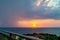 Sunset and rain at sea in the same photo. Sunlight and rainy clouds in the horizon at sea.