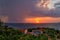 Sunset and rain at sea in the same photo. Sunlight and rainy clouds in the horizon at sea.