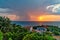 Sunset and rain at sea in the same photo. Sunlight and rainy clouds in the horizon at sea.