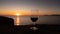 Sunset at the ramparts of alghero city with silhouette with two glasses of prosecco