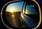 A sunset in the rearview mirror of car